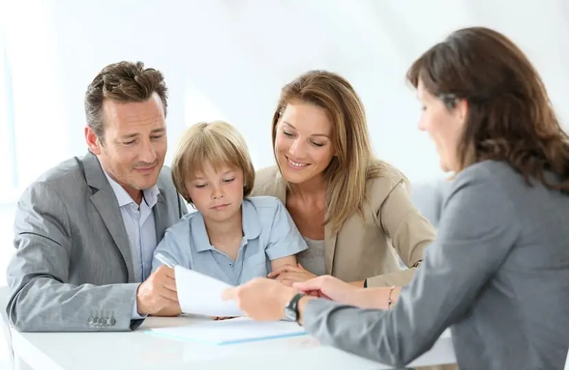 Una familia con un niño revisa documentación con una profesional.