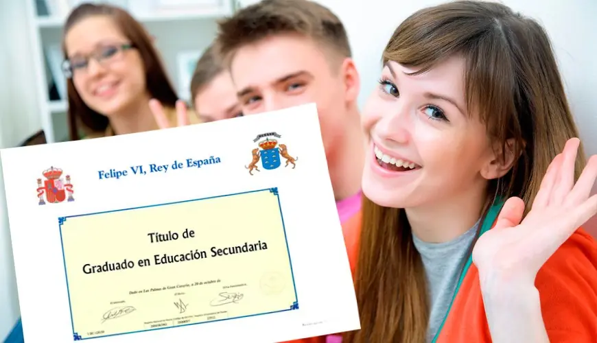 Una joven muestra un título de Graduado en Educación Secundaria junto a otros jóvenes.